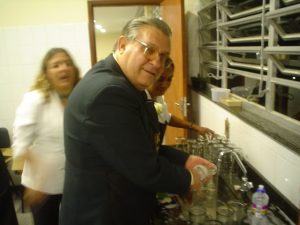 Ajudando a lavar as vasilhas na cozinha da Câmara